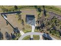 Aerial view of single Gathering home showing a spacious and well-kept lawn with surrounding green space outlined in yellow at 2668 Clovelon St, North Port, FL 34291
