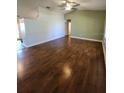 Spacious living room with wood floors and ceiling fan provides an airy atmosphere at 18085 Wintergarden Ave, Port Charlotte, FL 33948