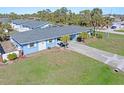 Charming single-story home with a well-manicured lawn, lush palm trees, and a private driveway at 1956 Wyoming Ave, Englewood, FL 34224