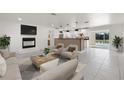 Bright, open living room with a fireplace and view of the kitchen and pool at 3429 Sleepy Hollow Ln, Punta Gorda, FL 33950