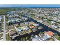 Aerial view of a waterfront home with canal access and a private boat dock, surrounded by lush landscaping at 520 Boardman Dr, Punta Gorda, FL 33950