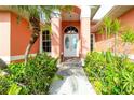 Charming home entrance with double doors, decorative glass, and lush landscaping at 126 Peckham Sw St, Port Charlotte, FL 33952