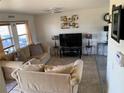 Inviting living room with neutral-colored furniture, tile flooring, and plenty of natural light at 3380 Maple Ter, Port Charlotte, FL 33952
