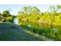 Scenic backyard with canal and mature trees offering a tranquil outdoor experience at 1426 Natrona Dr, North Port, FL 34286