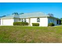 Charming single-story home with a two-car garage, manicured lawn, and arched windows at 1426 Natrona Dr, North Port, FL 34286