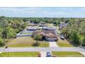 Expansive aerial view of a landscaped property with a two-car garage and surrounded by lush greenery at 23239 Stelling Ave, Punta Gorda, FL 33980