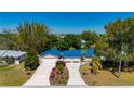 Charming exterior of a home with a new blue roof, well-manicured landscaping, and a double driveway offering ample parking at 28482 Coco Palm Dr, Punta Gorda, FL 33982