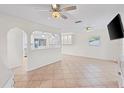 Bright living room with tile floors, ceiling fans, built in cabinets and archways leading to kitchen at 28482 Coco Palm Dr, Punta Gorda, FL 33982