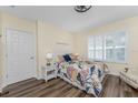 Cozy bedroom with plank flooring, plantation shutters, and a comfortable bed dressed with a floral comforter at 7393 West Lenox Cir, Punta Gorda, FL 33950