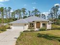 Charming single-story home with a two-car garage, arched entryway, and professionally landscaped front yard at 3896 Slayton Ave, North Port, FL 34286