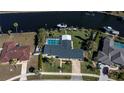 Aerial view of a home with pool and private dock on canal with boat at 125 Ott Cir, Port Charlotte, FL 33952