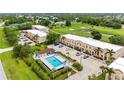 Aerial view of complex with a pool, parking and view of a golf course at 1186 Rio De Janeiro Ave # 106, Punta Gorda, FL 33983