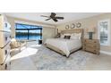 Bright primary bedroom with water view, features a king-size bed and sliding glass doors to outdoor at 1339 Casey Key Dr, Punta Gorda, FL 33950