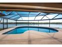 Gorgeous screened-in pool area features a uniquely shaped pool, perfect for relaxation and entertaining with waterfront view at 1339 Casey Key Dr, Punta Gorda, FL 33950