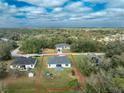 Aerial view showcasing the property and its surroundings, including a large backyard and nearby wooded areas at 3264 Garbett Ter, North Port, FL 34288