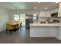 Bright eat-in kitchen featuring stainless steel appliances, white cabinets, gray floors, and views of the pool at 4128 Durant St, Port Charlotte, FL 33948
