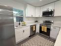 Bright kitchen features stainless steel appliances, white cabinets, and a window over the sink at 4128 Durant St, Port Charlotte, FL 33948