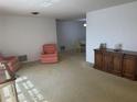 Spacious carpeted living room featuring clean white walls with views into the dining area at 432 Olivia Rd, Venice, FL 34293