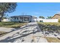 Single-story home with a light-blue exterior, fenced yard, and long driveway at 5909 Talbrook Rd, North Port, FL 34287