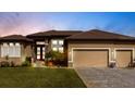 Charming, single-story home with a well-manicured lawn, paved driveway, and a two-car garage at sunset at 17122 Barcrest Ln, Punta Gorda, FL 33955