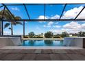 Beautiful pool showcasing cascading water features and a lovely view of the blue sky and distant trees at 17122 Barcrest Ln, Punta Gorda, FL 33955