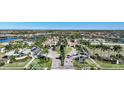 Grand community entrance with manicured landscaping, a gatehouse, and palm tree lined streets at 20272 Lagente, Venice, FL 34293