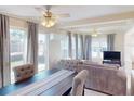 Cozy living room and dining area with a ceiling fan, neutral tones, and large windows with natural light at 21456 Holdern Ave, Port Charlotte, FL 33952