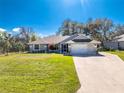 Charming single-story home featuring a well-maintained lawn and attached two-car garage at 27385 Neaptide Dr, Punta Gorda, FL 33983
