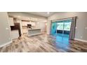 Open concept living space with wood-look floors and a view of the modern kitchen at 342 Sweetwater Dr, Rotonda West, FL 33947