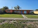 Charming one-story home with a lush lawn and a vibrant orange facade at 520 Sharon Cir, Port Charlotte, FL 33952