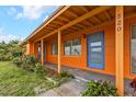 Inviting porch with orange siding and a striking blue front door at 520 Sharon Cir, Port Charlotte, FL 33952