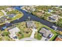 Stunning aerial view of the home, waterfront, boat docks, pool, lush landscaping, and neighborhood at 9428 Bandera Ln, Port Charlotte, FL 33981