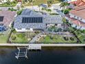 Aerial view of a beautiful home with a pool, solar panels, a canal, and a boat dock at 1105 Rum Cay Ct, Punta Gorda, FL 33950