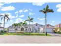 Charming one-story home featuring palm trees, a tile roof, an attached garage, and a well-kept lawn at 1105 Rum Cay Ct, Punta Gorda, FL 33950