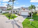 Attractive single-story home boasting a tile roof, paved driveway, mature palms and a green lawn at 1105 Rum Cay Ct, Punta Gorda, FL 33950