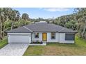Charming single-story home featuring a striking yellow door, manicured lawn, and spacious driveway at 1117 Vernon Ave, Port Charlotte, FL 33948