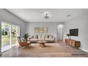 Bright, neutral living room featuring a comfortable sofa, stylish decor, and sliding glass doors at 1117 Vernon Ave, Port Charlotte, FL 33948