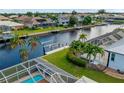 Backyard view with canal access including dock, pool and screen lanai enclosure at 1118 Treasure Cay Ct, Punta Gorda, FL 33950