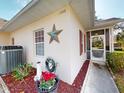 Charming home exterior with landscaped garden, window shutters and a quaint screened-in entryway at 1286 Green Oak Trl, Port Charlotte, FL 33948