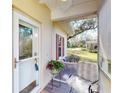 Inviting porch with white-framed front door and comfortable chair overlooking the well-maintained neighborhood at 1286 Green Oak Trl, Port Charlotte, FL 33948