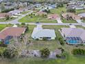 Aerial view of a neighborhood, showcasing a yellow single-story home with mature landscaping at 1364 Ultramarine Ln, Punta Gorda, FL 33983