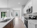 Modern kitchen features stainless steel appliances, white cabinets, and a contrasting dark wood island at 1818 New London St, North Port, FL 34288