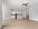 Open-concept living area with tile flooring, kitchen island, and a ceiling fan at 1818 New London St, North Port, FL 34288