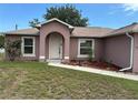 Inviting home featuring a white front door with an arched entryway, complemented by manicured landscaping at 20370 Mount Prospect Ave, Port Charlotte, FL 33952