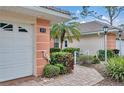 Exterior view of a house with a two-car garage, landscape decorations, and a paved walkway at 2175 Lynx Run, North Port, FL 34288