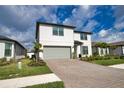 Charming two-story home featuring a gray two-car garage, landscaped yard, and a covered front entryway at 2208 Darley Oak Way, North Port, FL 34289