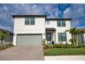 Charming two-story home featuring a gray two-car garage, landscaped yard, and a covered front entryway at 2208 Darley Oak Way, North Port, FL 34289
