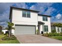 Charming two-story home featuring a gray two-car garage, landscaped yard, and a covered front entryway at 2208 Darley Oak Way, North Port, FL 34289