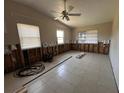 Spacious living room showing damage remediation, tiled floors, and a ceiling fan at 3120 Wisteria Pl, Punta Gorda, FL 33950