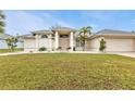 Inviting single-story home with manicured lawn, stone accents, and two-car garage at 73 Santarem Cir, Punta Gorda, FL 33983
